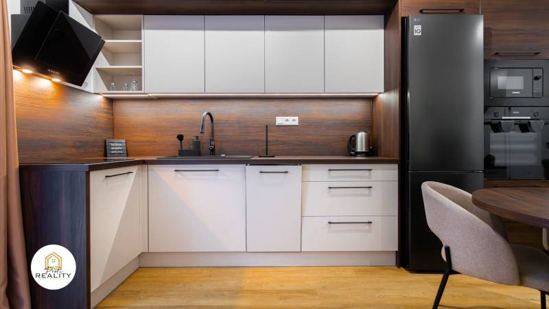 Küche in einer Einzimmerwohnung mit Holzboden und modernen Geräten.