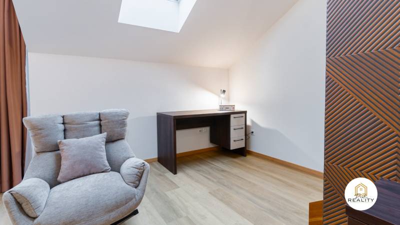 Sessel, Schreibtisch und Boden mit Holzdekor in einer Einzimmerwohnung.