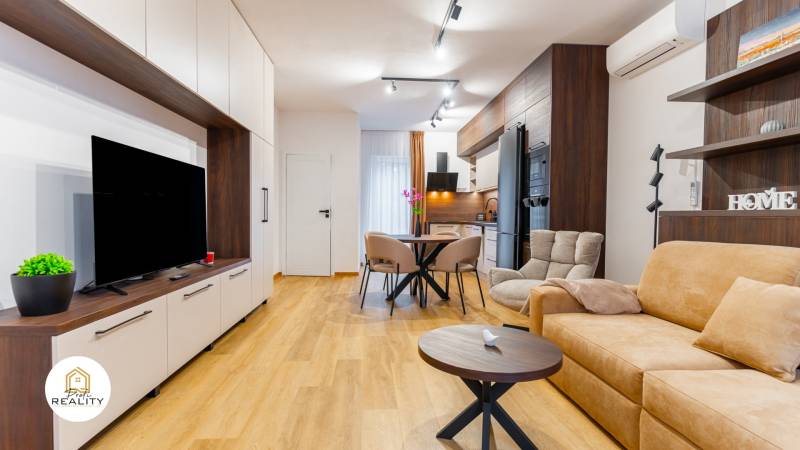 Wohnzimmer mit Holzboden, bequemer Couch und Küchentisch.