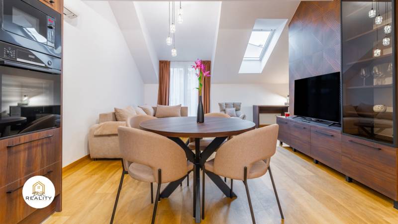 Innenraum einer Einzimmerwohnung mit Tisch, Sofa und Boden in Holzoptik.