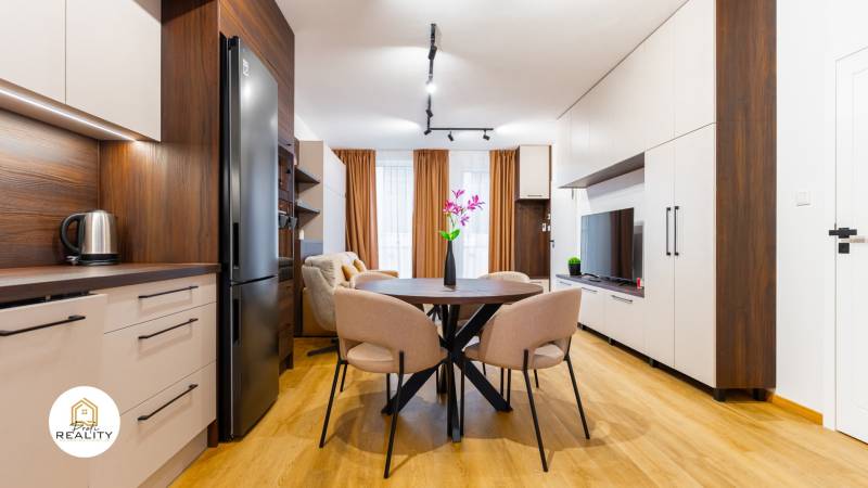 Innenraum einer Einzimmerwohnung mit Holzboden, Küche und Esstisch.