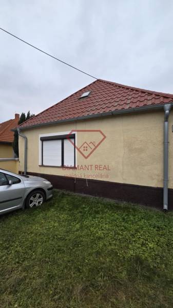 Das Einfamilienhaus in der Hauptstraße in Veľká Mača mit einem Auto auf dem Rasen.