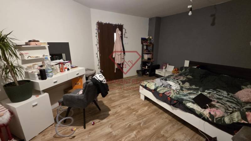 Schlafzimmer mit Bett, Schreibtisch und Holzboden in einem Einfamilienhaus.