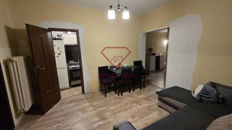 Wohnzimmer in einem Einfamilienhaus mit Holzboden, Tisch und Sofa.