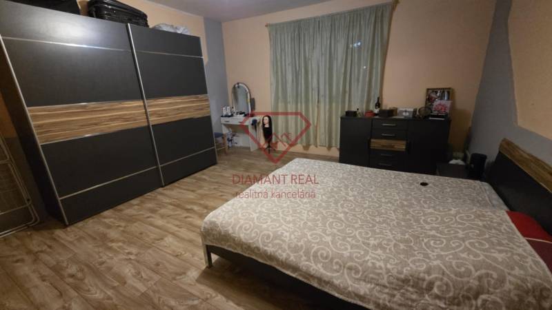 Ein Schlafzimmer in einem Einfamilienhaus mit Holzboden, einem Kleiderschrank und einem Bett.