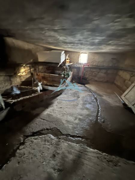 Keller im Einfamilienhaus in Demandice mit Steinwänden und einfacher Beleuchtung.