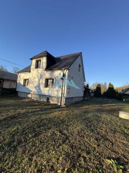 Ein Einfamilienhaus in Demandice mit zwei Etagen und einem begrünten Grundstück.