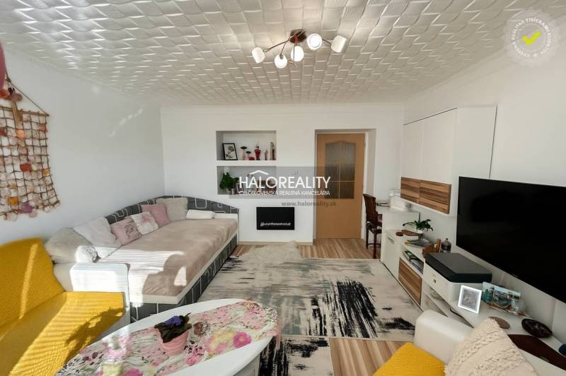 Wohnzimmer mit bequemer Couch in einer 2-Zimmer-Wohnung, Boden mit Holzdekor.