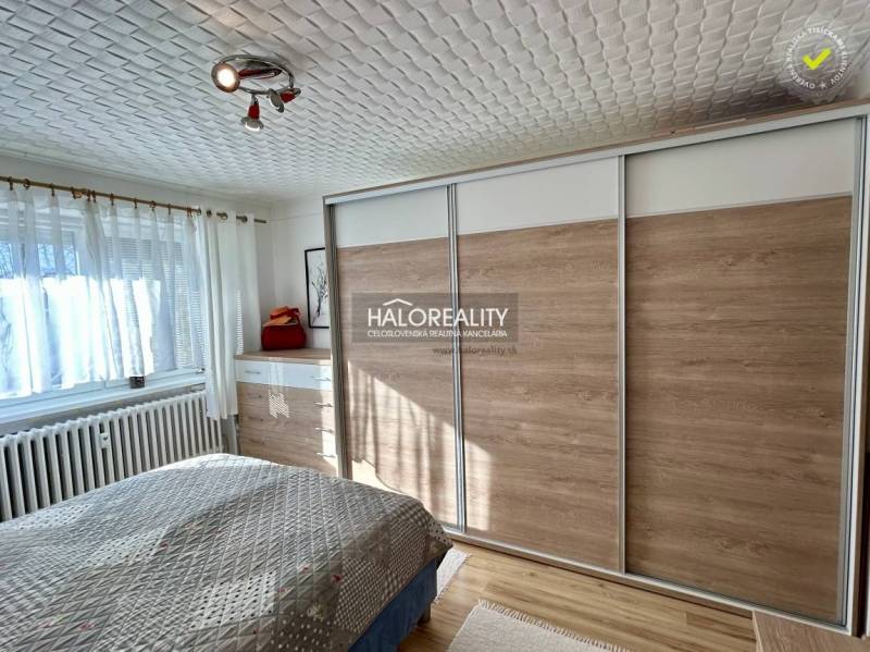 Schlafzimmer in einer 2-Zimmer-Wohnung mit Holzboden und einem großen Einbauschrank.