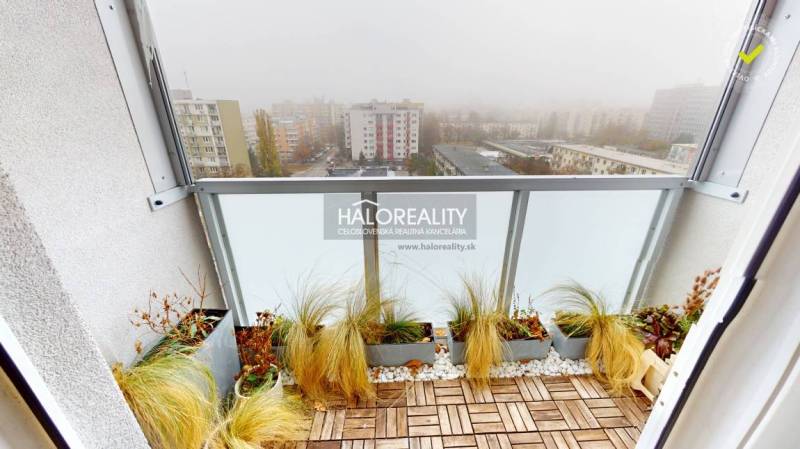 Balkon einer 3-Zimmer-Wohnung in Bratislava - Ružinov mit Blick auf die neblige Stadt, Holzboden-Dekor.