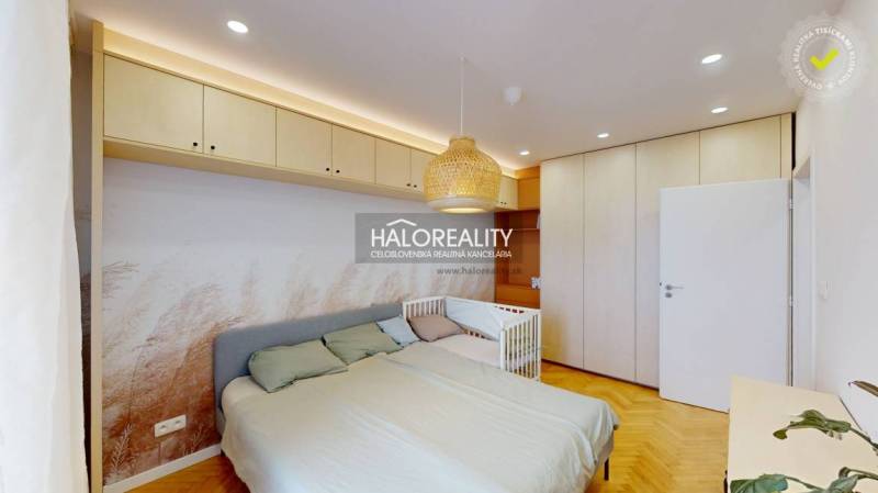 Schlafzimmer in einer 3-Zimmer-Wohnung mit Einbauschränken, Bett und Kinderbett.