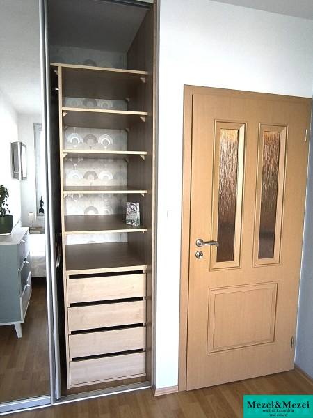Einbauschrank mit Regalen und Schubladen, in einer 2-Zimmer-Wohnung platziert.