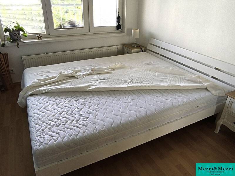 Stilvolles Schlafzimmer in einer 2-Zimmer-Wohnung mit Holzboden.