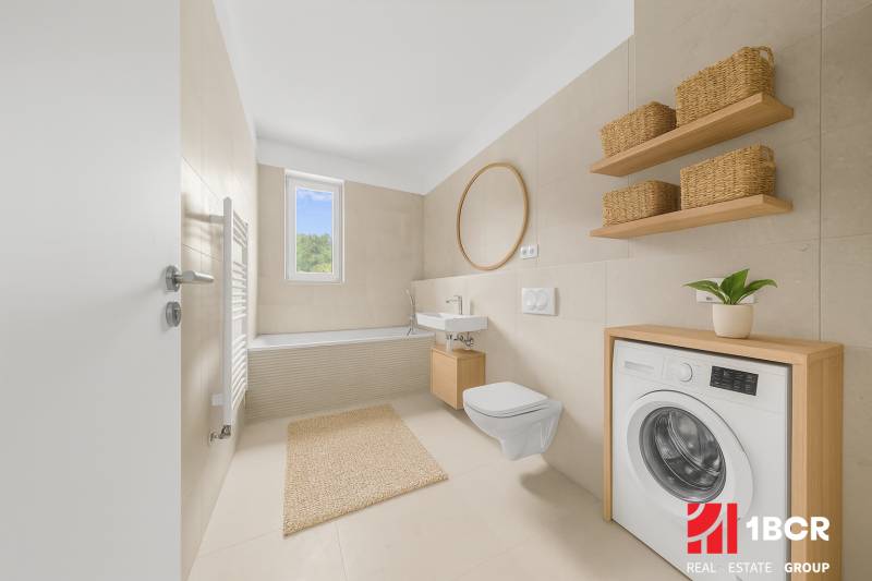Badezimmer mit Badewanne, Waschbecken, Spiegel und Waschmaschine in einer Zweizimmerwohnung.
