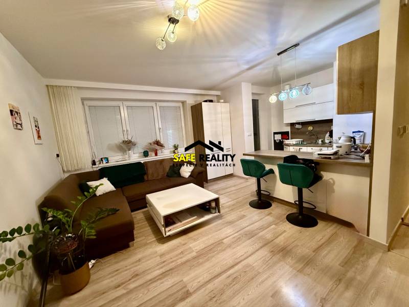 Wohnzimmer und Küche in einer Zweizimmerwohnung mit Holzboden.