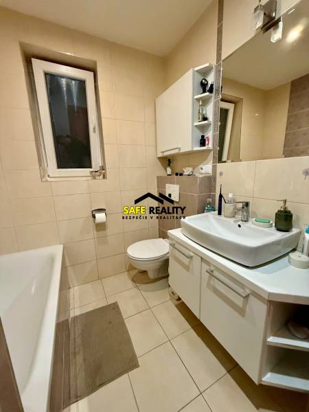 Badezimmer mit Badewanne und weißem Waschbecken in einer 2-Zimmer-Wohnung.