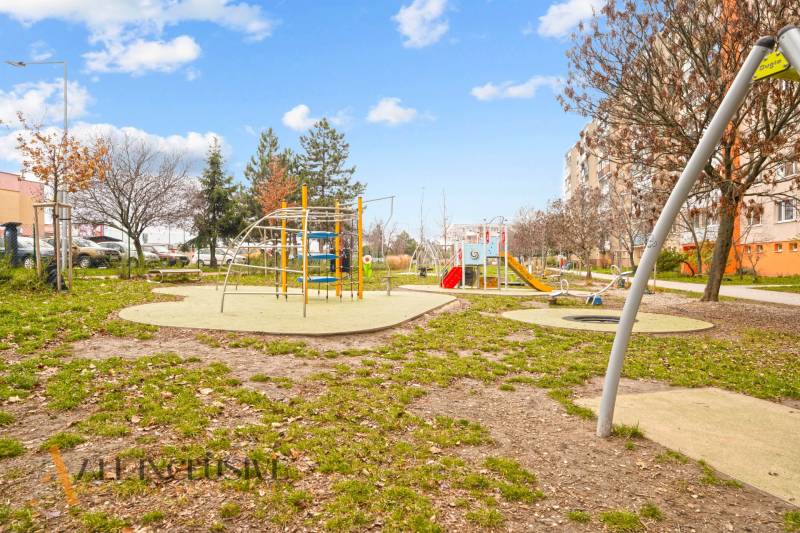 Ein Kinderspielplatz, umgeben von Plattenbauten in Senec, ideal für Familien mit Kindern.