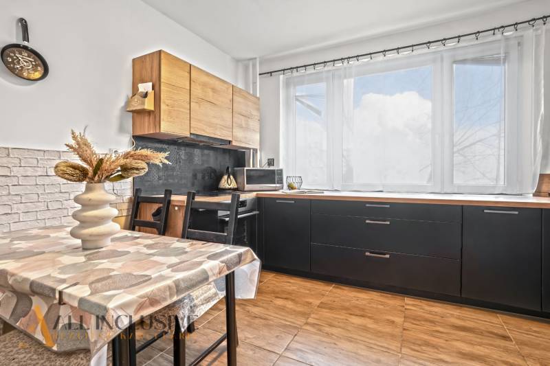 Küche in einer 3-Zimmer-Wohnung mit heller Dekoration und Holzboden.