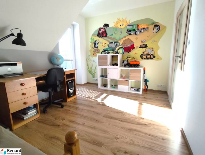 Kinderzimmer in einem Einfamilienhaus mit Holzboden und fröhlichem Wandgemälde.