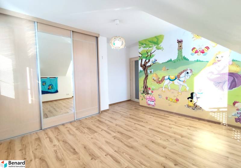 Kinderzimmer mit Holzboden, Schiebetürenschrank, bemalte Wand mit Naturmotiv.