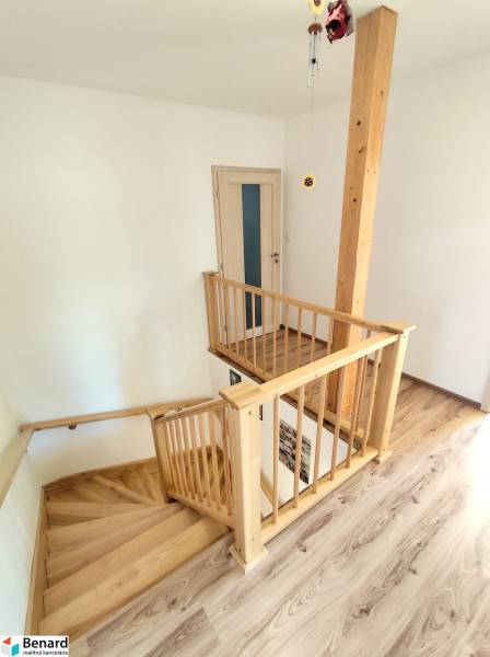 Im Inneren des Einfamilienhauses befinden sich eine Holztreppe und ein Boden mit Holzdekor.
