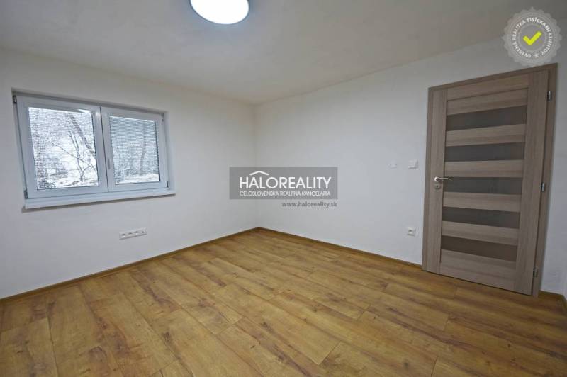 Ein leerer Raum in einem Einfamilienhaus mit Holzboden und einem Fenster.