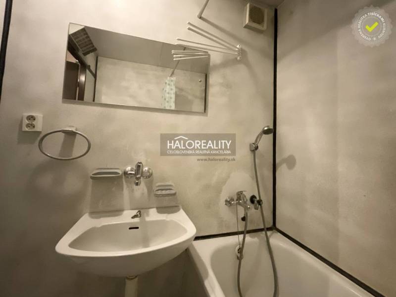 Badezimmer in einer 3-Zimmer-Wohnung mit Badewanne, Spiegel und weißem Waschbecken.