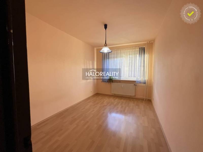 Leerer Raum mit Fenster, Vorhang, Holzboden, Licht und Heizkörper.