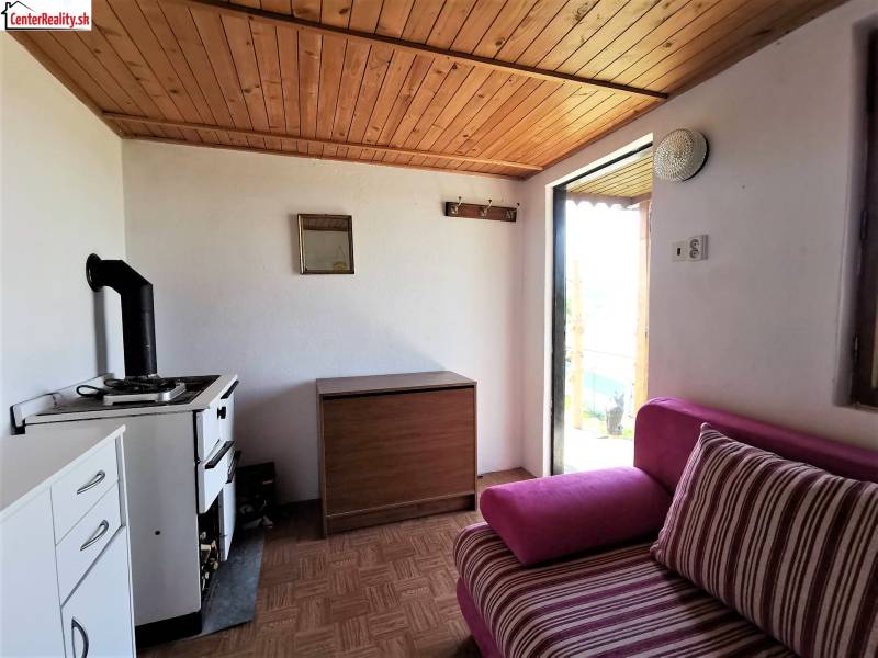 In der gemütlichen Hütte gibt es einen Vintage-Herd, eine Holzdecke und ein bequemes Polstersofa.