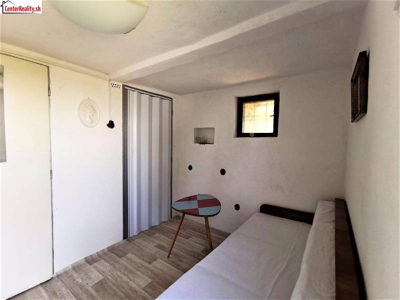 Die Hütte enthält einen gemütlichen Raum mit einem Sofa, einem Tisch und einem Holzboden.