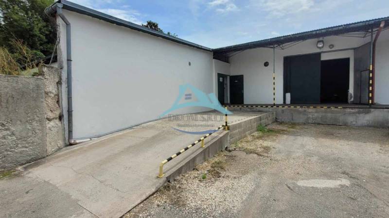 Lagerhäuser und Hallen in der Železničná-Straße mit Zufahrtsrampe und Ladebereich.