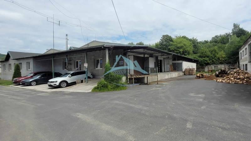 An der Straße Železničná steht bei den Lagern und Hallen ein Gebäude mit Autos und Holz.