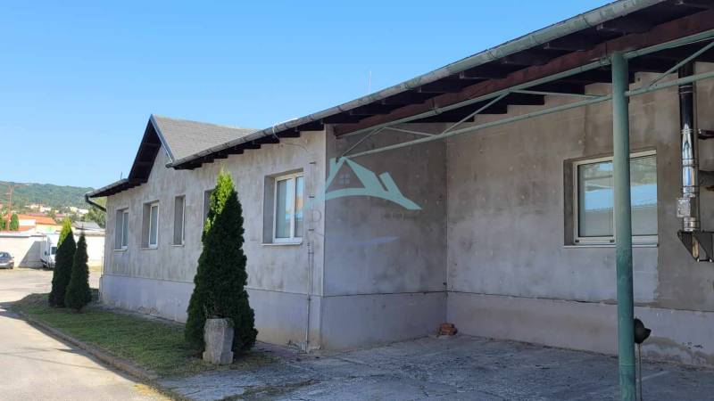 Industriegebäude in der Straße Železničná, umgeben von Grünflächen, Hallen und Lager im Hintergrund.