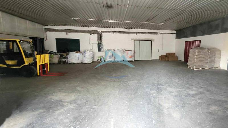 Lagerhaus in der Eisenbahnstraße: Innenraum mit Palettenhubwagen und Paketen, Lagerfläche.