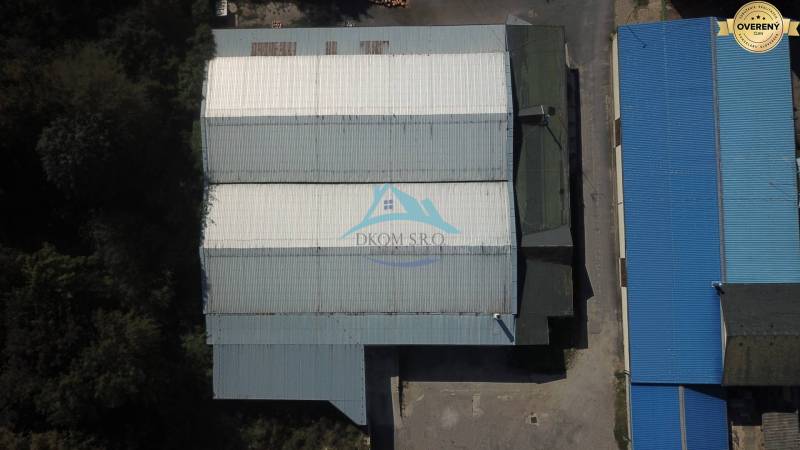 In der Straße Železničná befinden sich große Lagerhallen mit blauen Dächern.