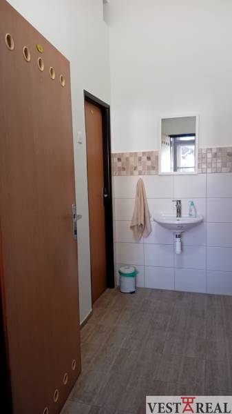 Büros mit Waschbecken, Spiegel und Boden mit Holzdekor.