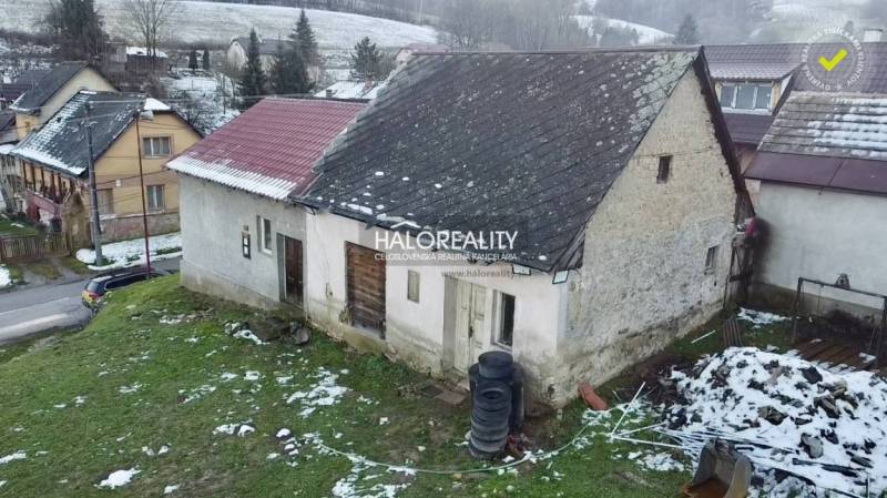 Ein Einfamilienhaus in Klenovec mit einem älteren Dach und einem verschneiten Grundstück.