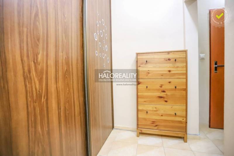 Der Flur mit einem Schrank und einer Kommode in einer 2-Zimmer-Wohnung mit Fliesen.