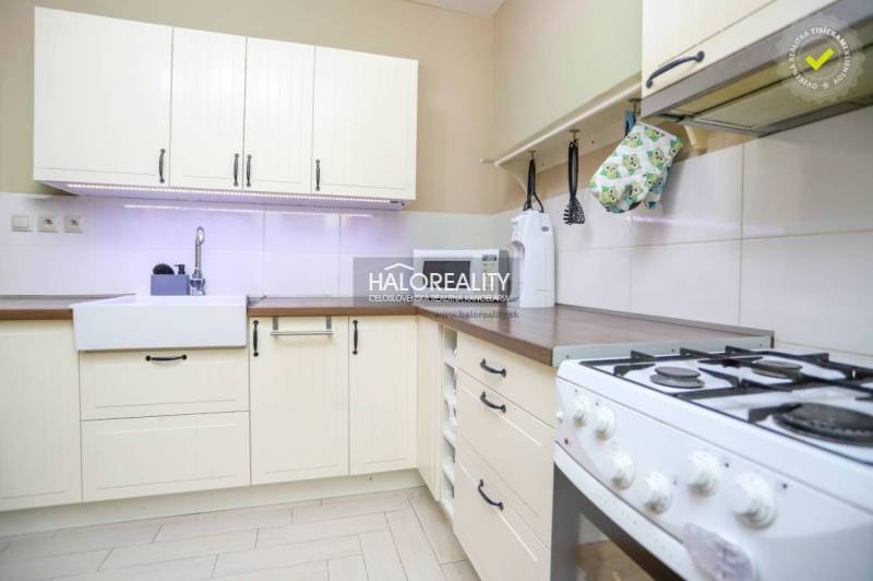 Küche in einer 2-Zimmer-Wohnung mit rustikalen Schränken und einem Gasherd, helles Design.