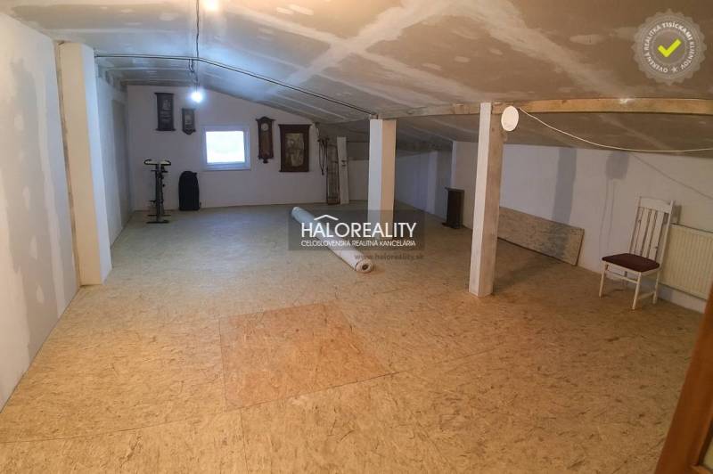 Dachbodenraum mit Fenster in einem Einfamilienhaus, Boden mit Holzdekor, Heimtrainer.