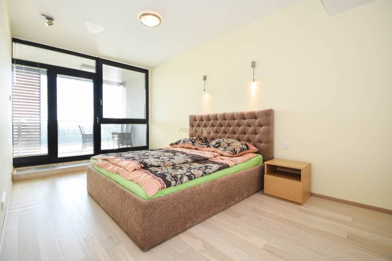 Schlafzimmer in einer 3-Zimmer-Wohnung mit einem bequemen Bett und einem Boden in Holzoptik.