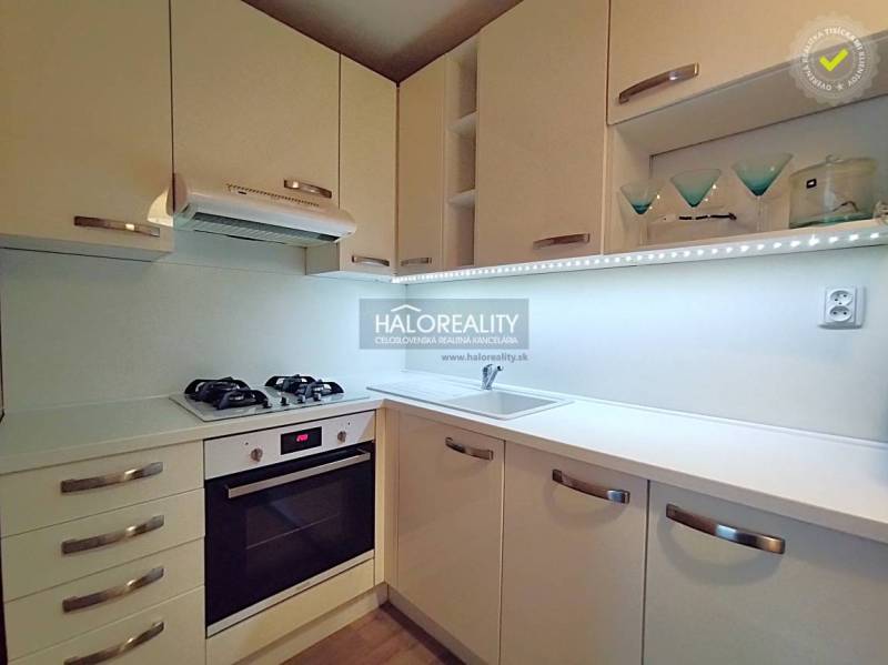 Küche in einer 2-Zimmer-Wohnung mit weißen Schränken, Gasherd und Stauraum.