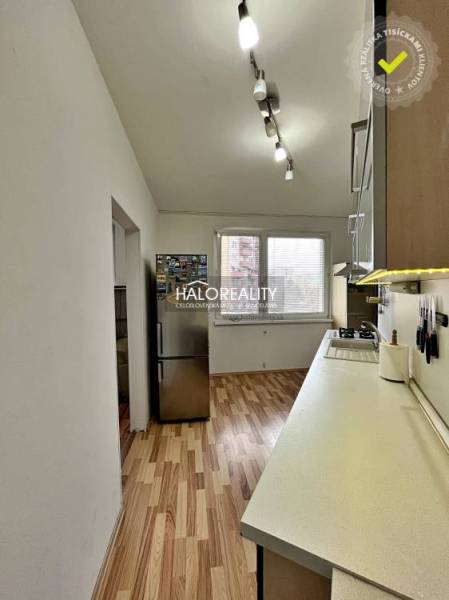 Die Küche in einer 3-Zimmer-Wohnung mit einem Holzboden und weißen Wänden.