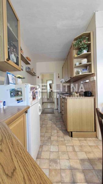 Küche in einer 2-Zimmer-Wohnung mit Holzdekor und weißen Wänden.