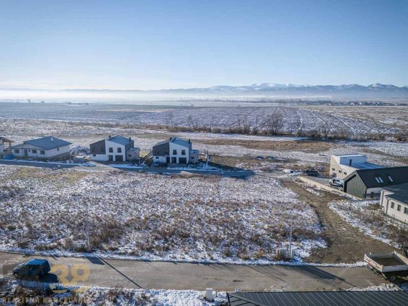 Mlynica: Grundstücke - Wohnen mit verschneiten Feldern und Häusern, umgeben von Wäldern und Straßen.