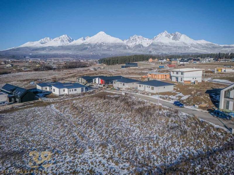 Verschneite Wohnbaugrundstücke in Mlynica mit Panoramablick auf die Berge.
