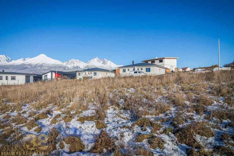 Grundstücke zum Wohnen in Mlynica mit Panoramablick und modernen Gebäuden im Hintergrund.