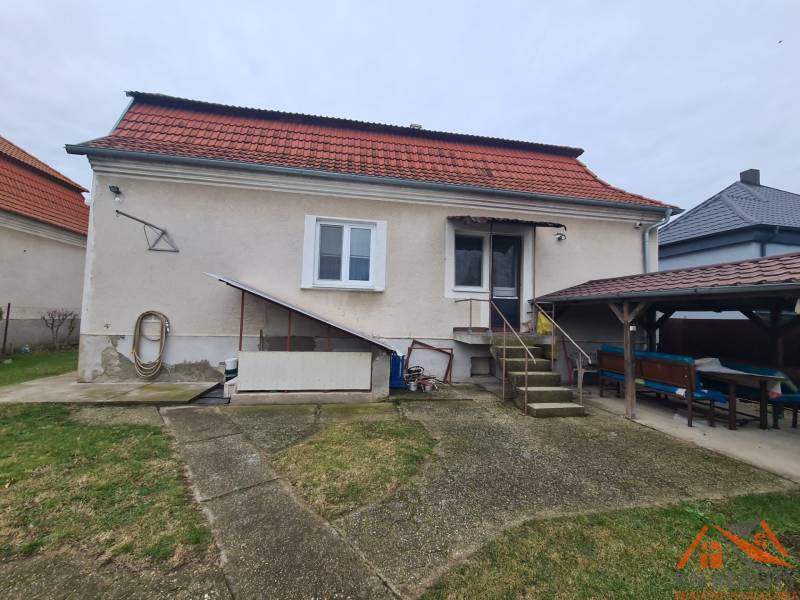 Ein Einfamilienhaus in Hurbanovo mit rotem Dach und einer Außensitzgelegenheit im Garten.