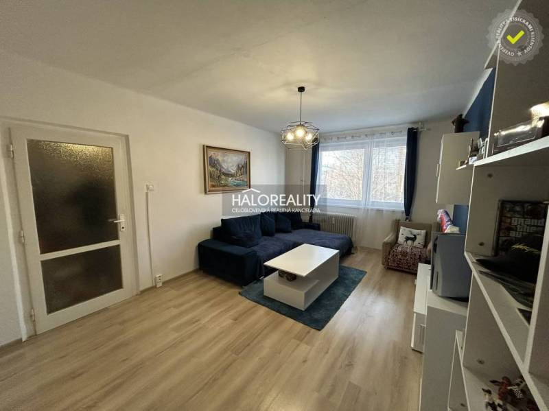 Wohnzimmer in einer 2-Zimmer-Wohnung mit Holzboden und bequemer Couch.