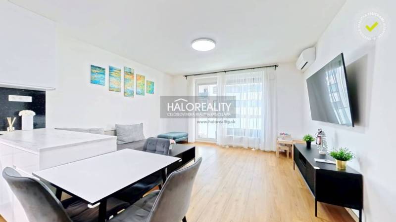 Wohnzimmer in einer Zweizimmerwohnung mit Holzboden und Möbeln.